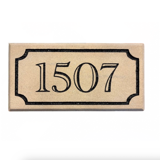 A rectangular beige house number plaque with black border and the numbers 1507 in black serif font, shown on a white background.